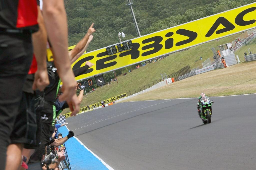 El 58 % de victorias de Kawasaki en Superbike han sido de la mano de Jonathan Rea, un dato escalofriante. También por vez primera esta temporada fue el que más puntos logró en el computo global del fin de semana, 50. Al fondo de la imagen, Toprak Razgatlioglu, quien completó el podio con Danilo Petrucci en tercera posición.